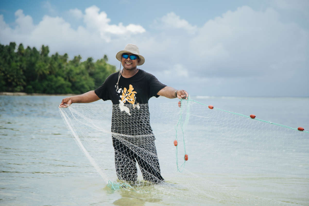 Fisherman in ocean with his net