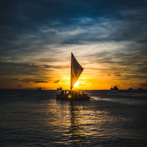 Sailboat in the ocean during sunset
